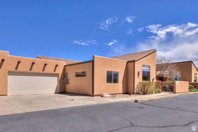 3686 S Spanish Valley Dr Unit K-2, Moab, UT 84532 - view of front facade featuring concrete driveway, stucco siding, a tile roof, and a garage