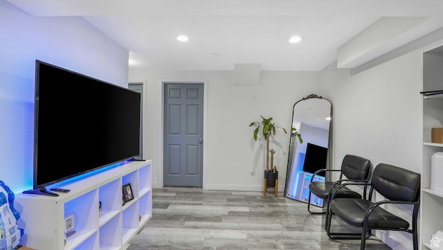 living area featuring baseboards, light wood finished floors, and recessed lighting