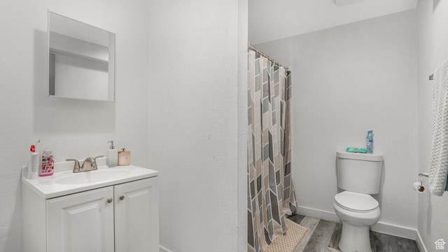 bathroom featuring vanity, toilet, a shower with shower curtain, and wood finished floors
