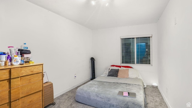 bedroom with light colored carpet and baseboards