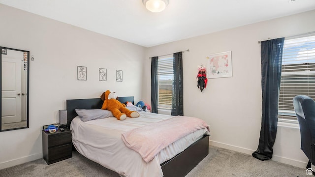 bedroom featuring baseboards and light carpet