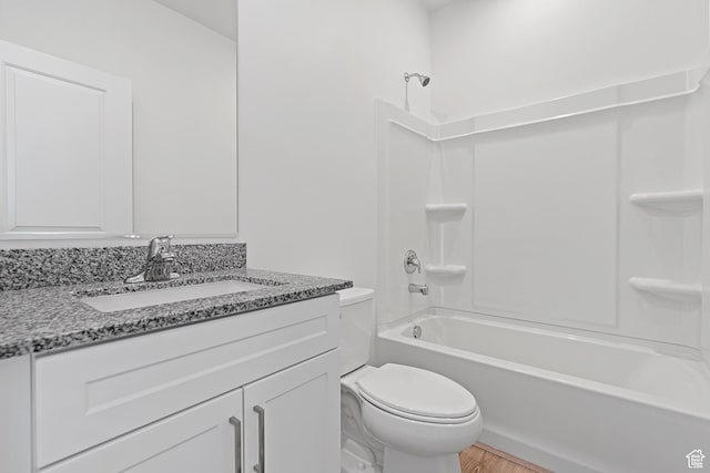 bathroom with toilet, bathing tub / shower combination, vanity, and wood finished floors