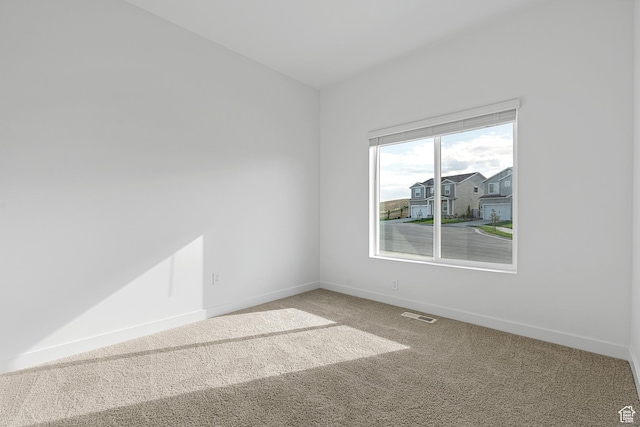 empty room with carpet, baseboards, and visible vents