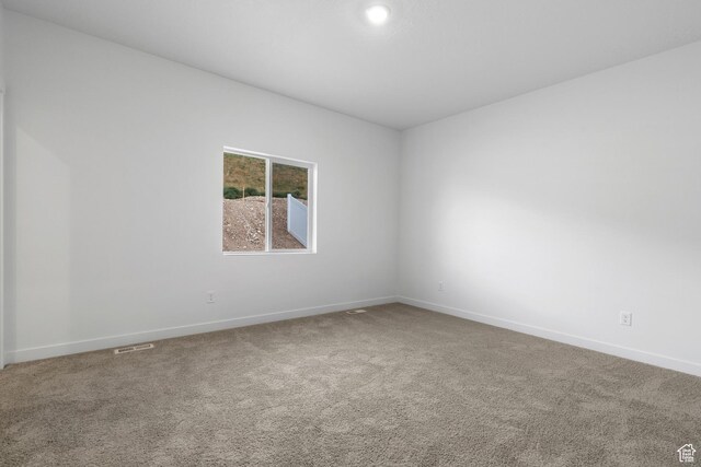 unfurnished room with carpet, baseboards, and visible vents