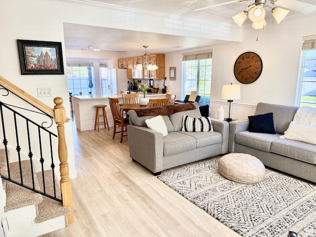 747 N 200 E, Springville, UT 84663 - living room with light wood-type flooring, ceiling fan with notable chandelier, ornamental molding, and stairs