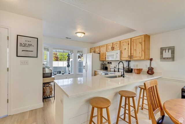747 N 200 E, Springville, UT 84663 - kitchen featuring a sink, a peninsula, white appliances, a kitchen bar, and light countertops