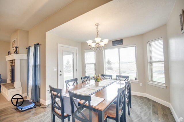 249 E 1800 N, Beaver, UT 84713 - dining room with wood finished floors, a chandelier, baseboards, and a fireplace with raised hearth