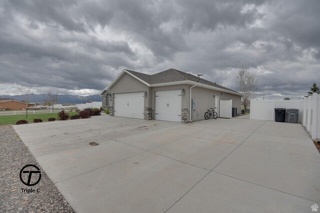 249 E 1800 N, Beaver, UT 84713 - view of side of property with stucco siding, a garage, fence, driveway, and stone siding
