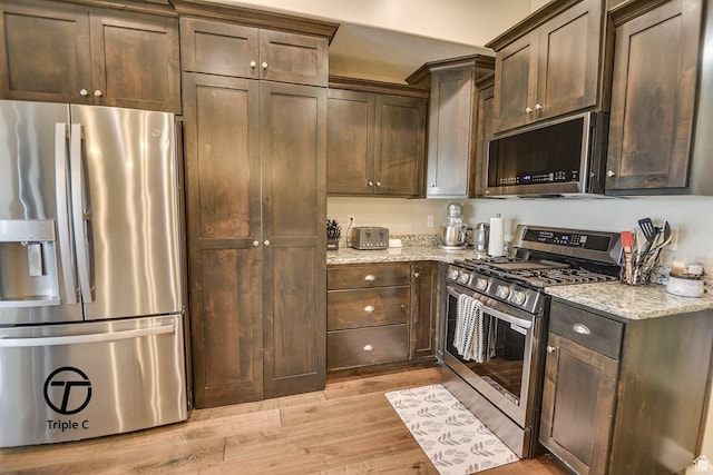249 E 1800 N, Beaver, UT 84713 - kitchen featuring appliances with stainless steel finishes, light stone counters, light wood-style flooring, and dark brown cabinets