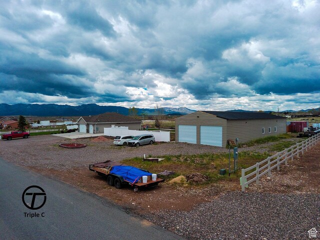 249 E 1800 N, Beaver, UT 84713 - view of front facade with a mountain view, fence, an outdoor structure, and a garage