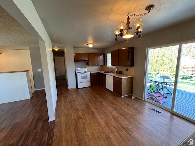 kitchen with white appliances, light countertops, dark wood-type flooring, and visible vents