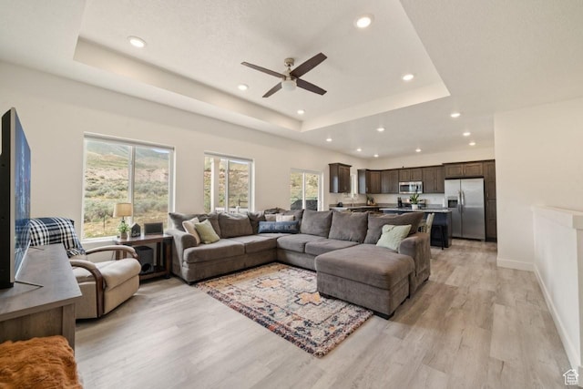 12735 W Kimberly Cir, Tremonton, UT 84337 - living room featuring a tray ceiling, light wood-type flooring, baseboards, ceiling fan, and recessed lighting