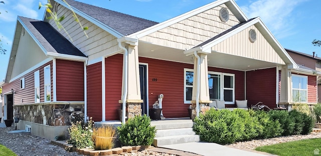 craftsman-style house featuring a porch and roof with shingles