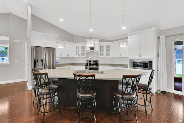 kitchen with a spacious island, light countertops, tasteful backsplash, and a sink