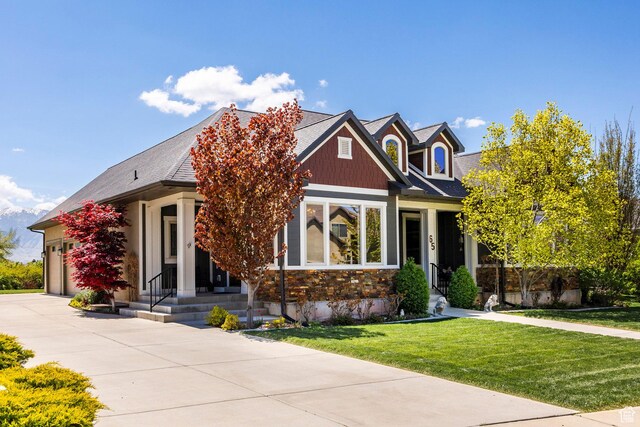 65 W Carnesecca Ct N, Mapleton, UT 84664 - craftsman-style house with a front yard, an attached garage, stone siding, and driveway