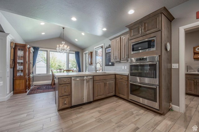 65 W Carnesecca Ct N, Mapleton, UT 84664 - kitchen featuring an inviting chandelier, a sink, a peninsula, vaulted ceiling, and stainless steel appliances