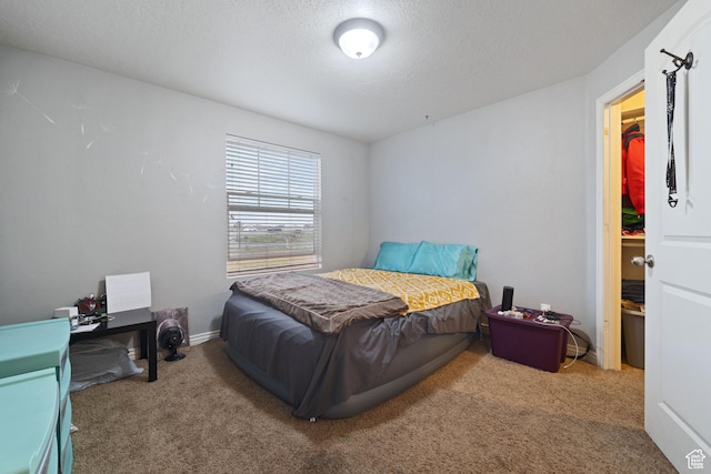 carpeted bedroom featuring a textured ceiling and baseboards