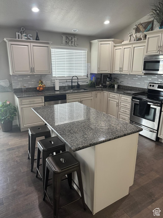 kitchen with recessed lighting, backsplash, stainless steel appliances, and a sink
