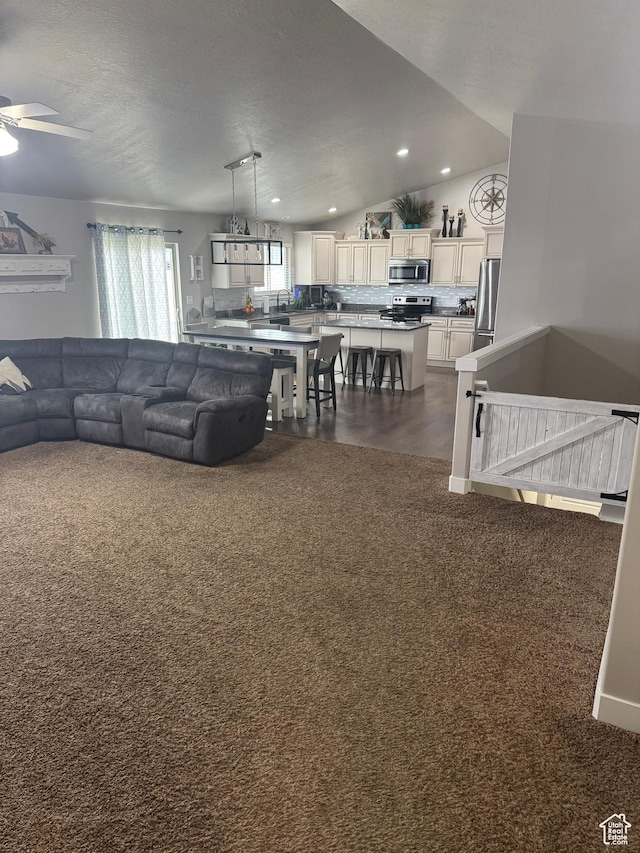 living area with dark colored carpet, a ceiling fan, and recessed lighting