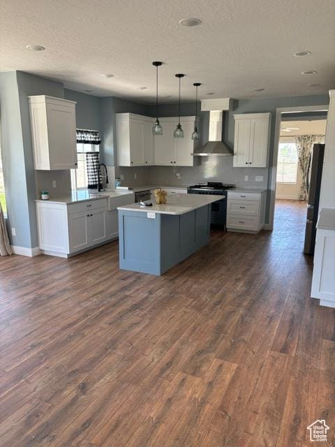 2577 W 5300 N Unit 11, Cedar City, UT 84721 - kitchen featuring wall chimney exhaust hood, stainless steel appliances, a textured ceiling, dark wood-type flooring, and white cabinets