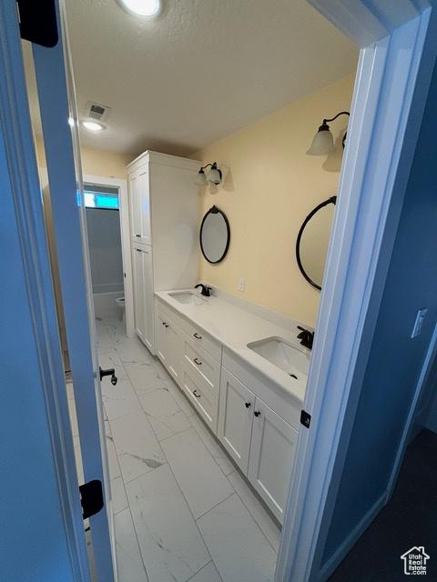 2577 W 5300 N Unit 11, Cedar City, UT 84721 - bathroom featuring marble look tile flooring, double vanity, and toilet