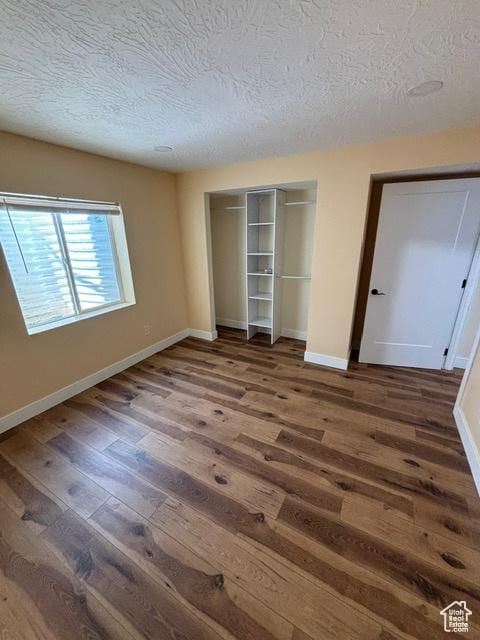 2577 W 5300 N Unit 11, Cedar City, UT 84721 - unfurnished bedroom with wood finished floors, a textured ceiling, a closet, and baseboards