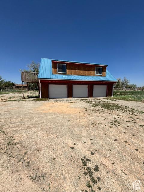 2577 W 5300 N Unit 11, Cedar City, UT 84721 - view of front of home with a detached garage, metal roof, and dirt driveway