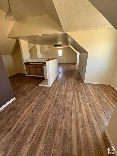 2577 W 5300 N Unit 11, Cedar City, UT 84721 - additional living space featuring dark wood-style floors, vaulted ceiling, baseboards, a textured ceiling, and a ceiling fan