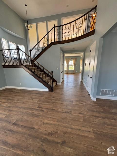 2577 W 5300 N Unit 11, Cedar City, UT 84721 - unfurnished living room with a high ceiling, baseboards, wood finished floors, and stairs