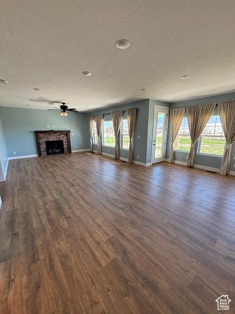 2577 W 5300 N Unit 11, Cedar City, UT 84721 - unfurnished living room with a textured ceiling, dark wood-type flooring, baseboards, plenty of natural light, and recessed lighting