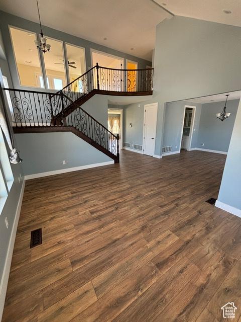 2577 W 5300 N Unit 11, Cedar City, UT 84721 - unfurnished living room featuring a chandelier, baseboards, wood finished floors, stairs, and high vaulted ceiling