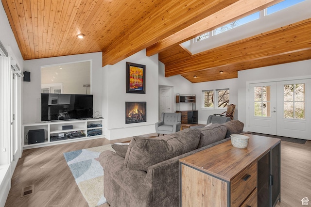 1303 Country Ln, Kamas, UT 84036 - living area with a warm lit fireplace, lofted ceiling with skylight, visible vents, and wooden ceiling
