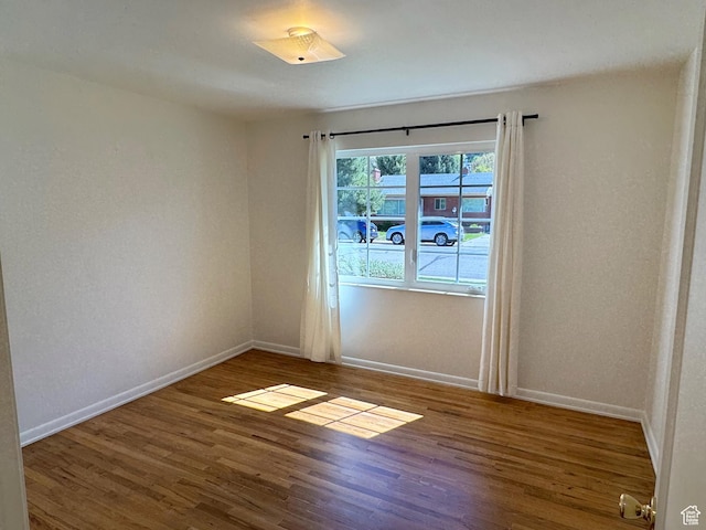empty room with baseboards and wood finished floors