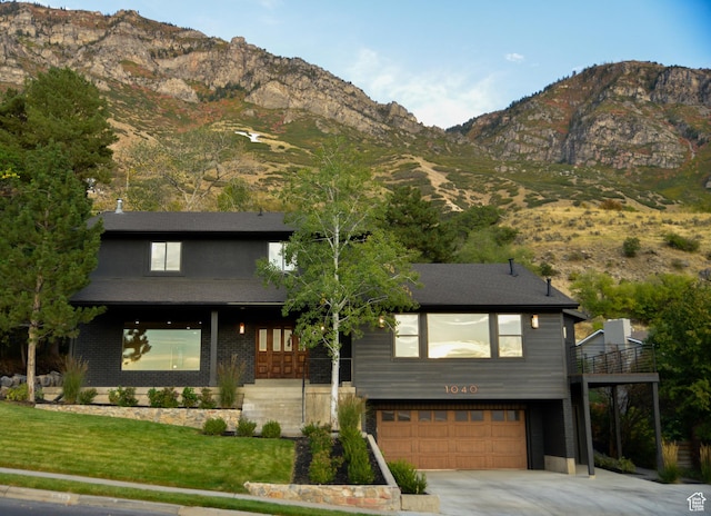 1040 N Oakmont Ln, Provo, UT 84604 - modern home with concrete driveway, a garage, a front lawn, and a mountain view