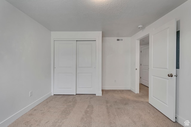 1679 S 1355 E Unit A21, Ogden, UT 84404 - unfurnished bedroom featuring light carpet, baseboards, a textured ceiling, and a closet