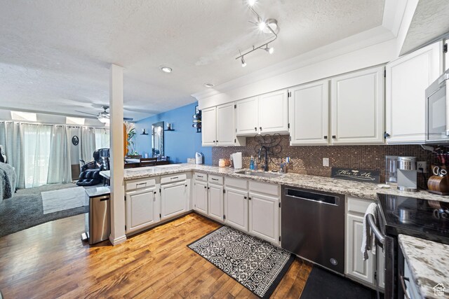 kitchen featuring stainless steel appliances, a sink, a ceiling fan, a textured ceiling, and light wood finished floors