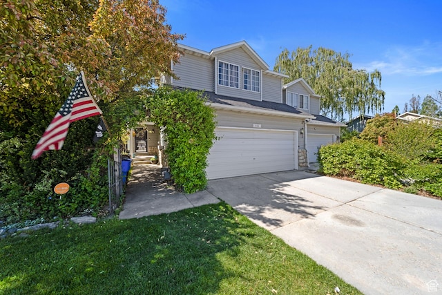 view of front of house with an attached garage, driveway, and a front lawn