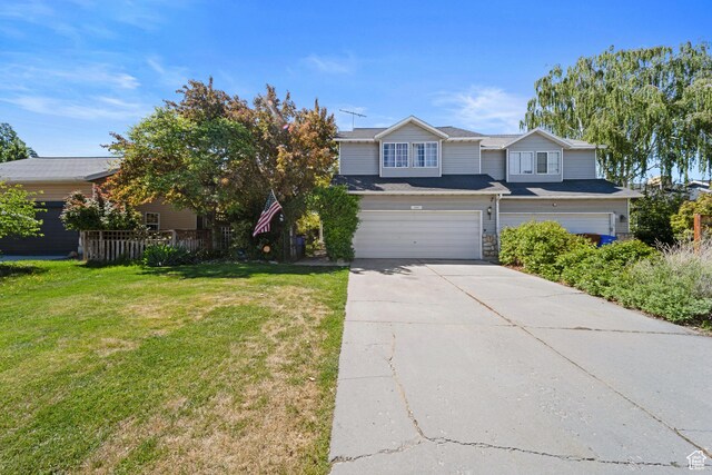 view of front facade featuring an attached garage, concrete driveway, and a front yard
