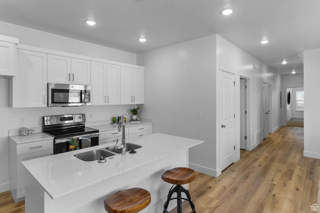 3085 S 225 W Unit 204, Nibley, UT 84321 - kitchen with recessed lighting, baseboards, light wood finished floors, a sink, and appliances with stainless steel finishes