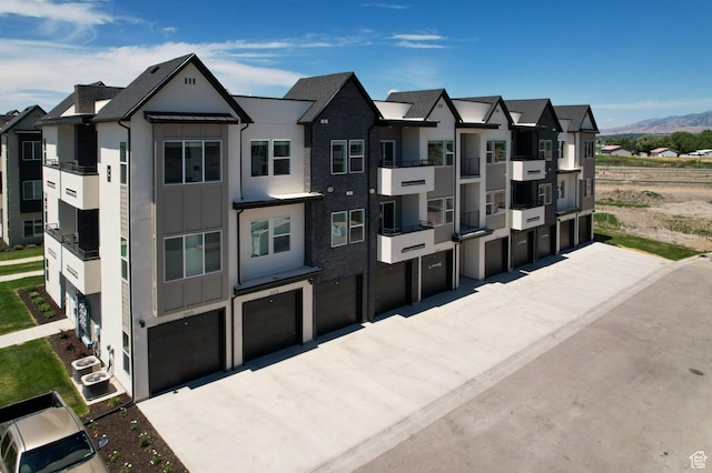 3085 S 225 W Unit 204, Nibley, UT 84321 - view of building exterior featuring a garage, a mountain view, and driveway