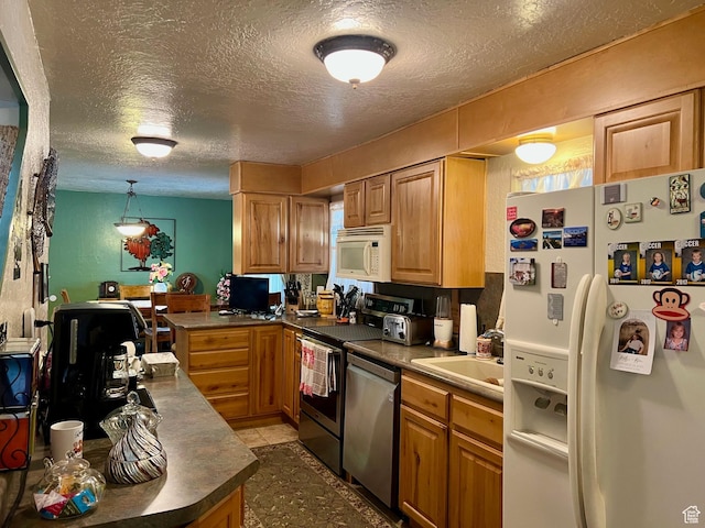 kitchen with a sink, a textured ceiling, white appliances, and dark countertops