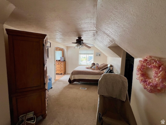 carpeted bedroom featuring ceiling fan, a textured ceiling, and vaulted ceiling