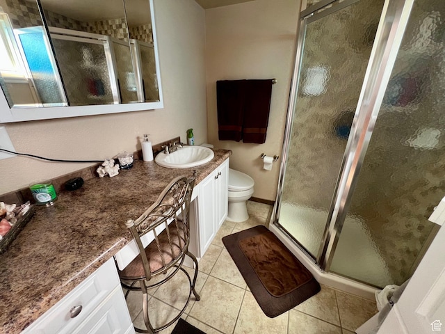 bathroom featuring tile patterned floors, toilet, a stall shower, and vanity