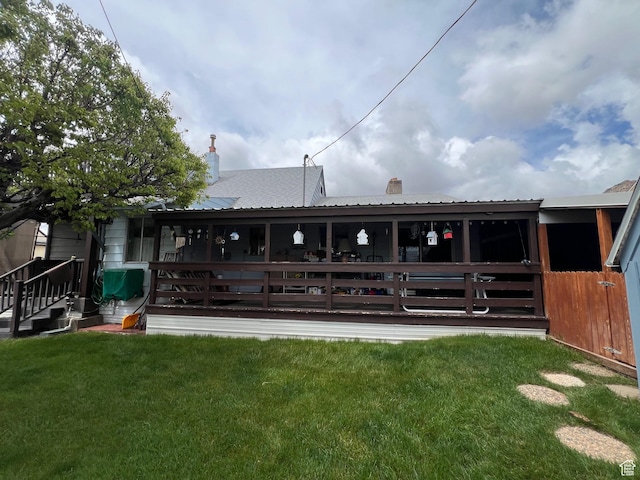 back of property featuring a chimney and metal roof