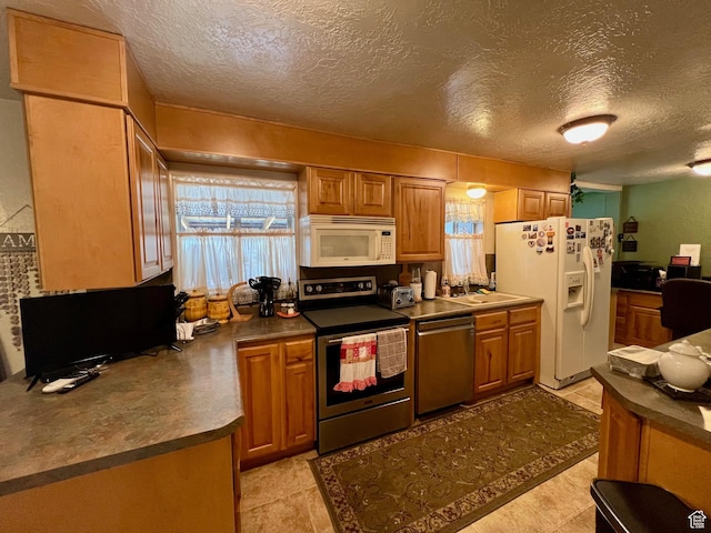 kitchen featuring dark countertops, a textured ceiling, and stainless steel appliances