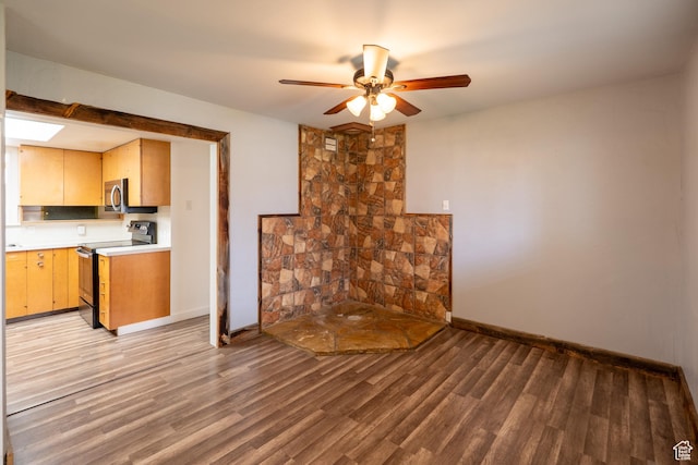 unfurnished living room with light wood-type flooring, baseboards, and ceiling fan