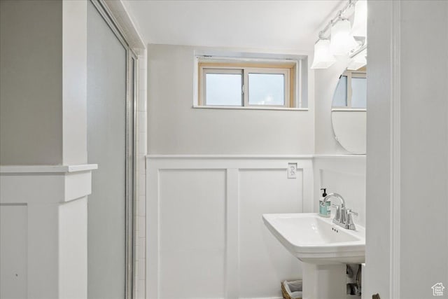 1704 E Herbert Ave, Salt Lake City, UT 84108 - full bathroom featuring a shower with shower door, a sink, a decorative wall, and a wainscoted wall