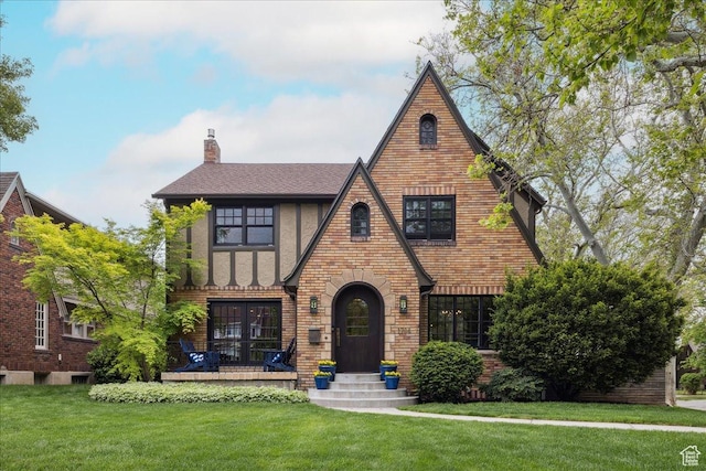 1704 E Herbert Ave, Salt Lake City, UT 84108 - english style home featuring brick siding, stucco siding, a front lawn, a chimney, and a shingled roof