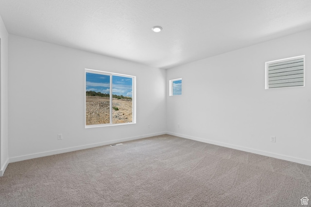 carpeted empty room with baseboards and visible vents