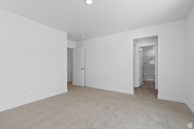 unfurnished bedroom with ensuite bath, baseboards, and carpet floors